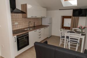 a kitchen and living room with a table and chairs at Apartmaji Tinta in Kanal
