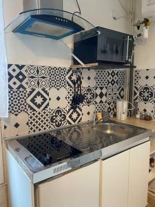 een keuken met een wastafel en een fornuis top oven bij Modern studio - Le Bourget Ideal JO 2024 in Le Bourget