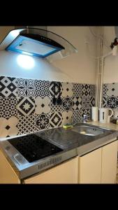 - une cuisine avec un évier et du carrelage noir et blanc dans l'établissement Modern studio - Le Bourget Ideal JO 2024, au Bourget