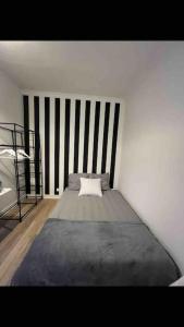 1 dormitorio con 1 cama en una pared blanca en Modern studio - Le Bourget Ideal JO 2024 en Le Bourget