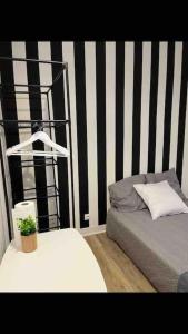 1 dormitorio con cama y pared a rayas en blanco y negro en Modern studio - Le Bourget Ideal JO 2024 en Le Bourget