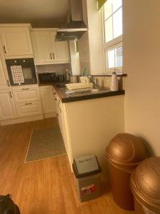 a kitchen with white cabinets and a sink and a window at Kilmore Beach Apartment in Tralee