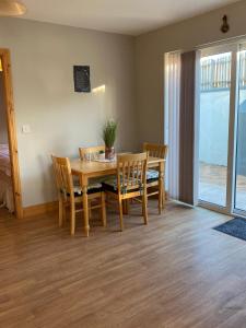 a dining room with a wooden table and chairs at Kilmore Beach Apartment in Tralee