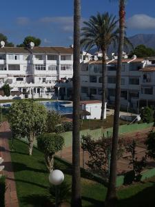 a view of a resort with palm trees and a swimming pool at Apartamento Aquila Parque in Fuengirola
