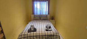a bedroom with a bed with two cats sitting on it at Apartamento Aquila Parque in Fuengirola