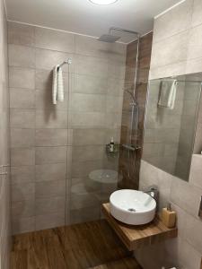 een badkamer met een witte wastafel en een douche bij Warsaw View Apartment in Warschau