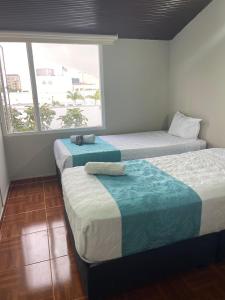 Duas camas num quarto com uma janela em HOTEL LUXEM em Bogotá