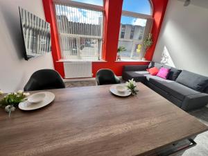 a living room with a wooden table and a couch at Flat 1 - Luxury Bolton City Centre Apartments in Bolton