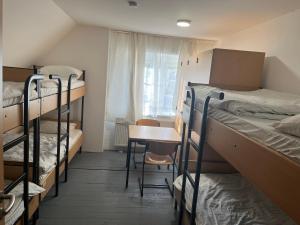a dorm room with several bunk beds and a table at Waldschlösschen Ricklingen in Hannover