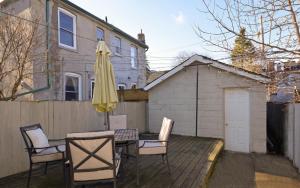 a patio with a table and chairs and an umbrella at Modern Condo 1BR - Near Trinity Bellwoods Park in Toronto