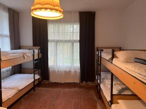 a room with three bunk beds and a window at Waldschlösschen Ricklingen in Hannover