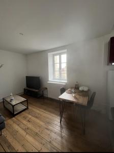 een woonkamer met een tafel en een televisie bij Centre Bayeux in Bayeux