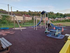 an empty playground with a slide and a bench at Stunning 2-Bed House in Ferryside in Ferryside