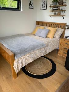 a bed in a bedroom with a rug on the floor at Cedar Cabin in Newbury
