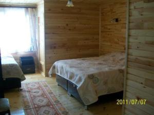 1 dormitorio con 1 cama en una habitación con paredes de madera en Dedaena Pansiyon, en Artvin