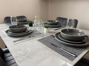 a table with black plates and glasses on it at Duplex Apartment in Greater Manchester in Oldham