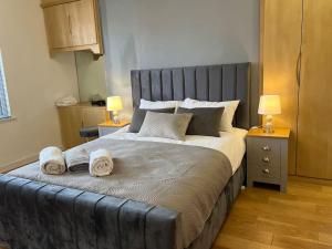 a bedroom with a large bed with towels on it at Duplex Apartment in Greater Manchester in Oldham