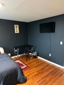 um quarto com uma cama e uma televisão de ecrã plano em Fidelia Room B Queen Bed Near EWR Airport and Penn Station em Irvington