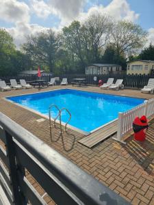 a large swimming pool with chairs and ahaps at PB6 in Bettws-Evan