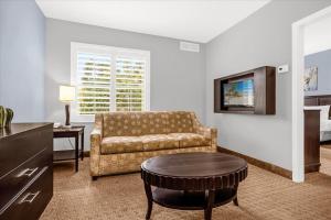 a living room with a couch and a table at 1BR Condo - Two Queens Arcade Pool - Near Disney in Orlando