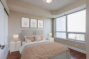 a bedroom with a bed and a large window at Delta Suites - North York in Toronto