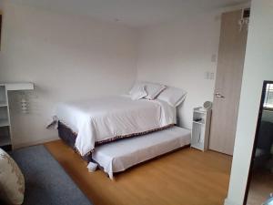 1 dormitorio con 1 cama con sábanas blancas en HOMY APARTAMENTOS - Corferias, embassy, airport, G12, UN, Agora, en Bogotá