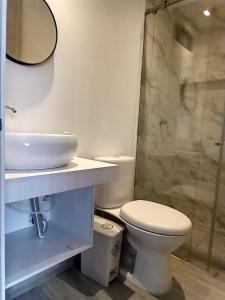 La salle de bains est pourvue de toilettes, d'un lavabo et d'une douche. dans l'établissement HOMY APARTAMENTOS - Corferias, embassy, airport, G12, UN, Agora, à Bogotá