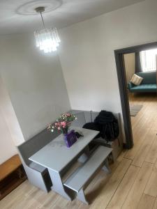 Cosy Widnes Home في ويدنز: غرفة مع طاولة و مزهرية عليها زهور