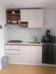 - une cuisine blanche avec évier et cuisinière dans l'établissement HOMY APARTAMENTOS - Corferias, embassy, airport, G12, UN, Agora, à Bogotá