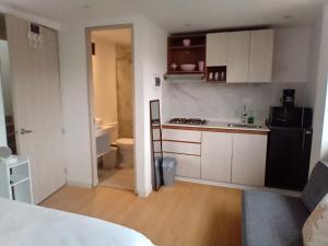 a kitchen with white cabinets and a black refrigerator at HOMY APARTAMENTOS - Corferias, embassy, airport, G12, UN, Agora in Bogotá +136 photos