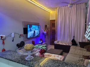 sala de estar con sofá y mesa con piña en Sobrado de condominio Praia Grande VilaTupi com 2 dormitorio, en Praia Grande