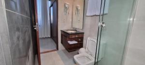 a bathroom with a toilet and a sink and a shower at Hotel Maywa in Santa Cruz de la Sierra