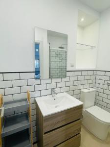 a bathroom with a sink and a toilet and a mirror at Casa Cervantes Malaga in Málaga
