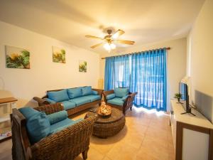 a living room with a couch and a tv at 2br Caribbean Condo In Cabarete Center in Cabarete