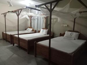 two beds in a room with twothirds at St Paul's Hostels Buhabugali Kigoma in Kigoma