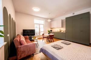 a living room with a bed and a kitchen at Trip Apartments in Krakow