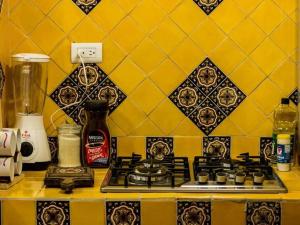 阿瓜斯卡連特斯的住宿－casita plaza de toros，厨房柜台设有炉灶和黄色的墙壁