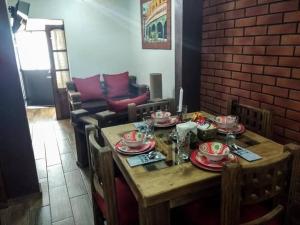 阿瓜斯卡連特斯的住宿－casita plaza de toros，客厅里一张带盘子和盘子的木桌
