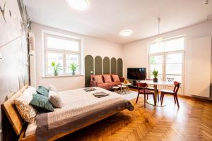 una sala de estar con una cama y una mesa en Trip Apartments, en Cracovia