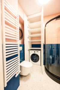 Un baño con inodoro y lavadora. en Trip Apartments, en Cracovia