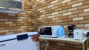 a microwave on a counter next to a brick wall at استراحه فندقيه فخمه نطاق المدينه بخصم ترويجي in Billah