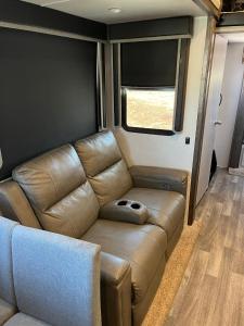 a leather couch in an rv with a window at Unique 2 Bedroom Campsite on the backside of Zion in Apple Valley