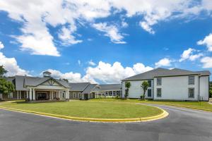 桑蒂Quality Inn & Suites的一座带圆形车道的大型白色房屋
