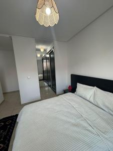 a bedroom with a large bed and a chandelier at welcome to ur appr in Agadir