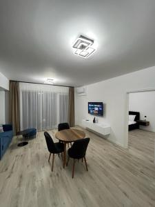 uma sala de estar com uma mesa e cadeiras e uma televisão em Premium Residence ApartHotel em Oradea