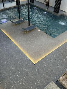 una piscina con dos bancos junto al agua en استراحه فندقيه فخمه نطاق المدينه بخصم ترويجي, en Billah
