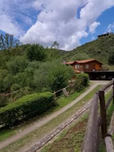 una valla de madera junto a una casa en una colina en Cabañas Legado Alemán en Villa General Belgrano