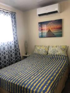 una camera con un letto con una coperta a righe blu e bianche di Stay and Dive a Cuajiniquil