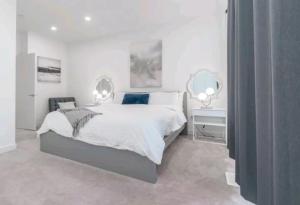 卡爾加里的住宿－City Escape Oasis，一间白色卧室,配有一张大床和两面镜子