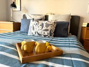 a tray with two yellow mugs on a bed at Cozy apartment near Los Boliches Beach in Fuengirola